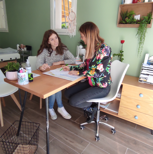 le naturopathe fait un bilan de santé à sa patiente assise à son bureau